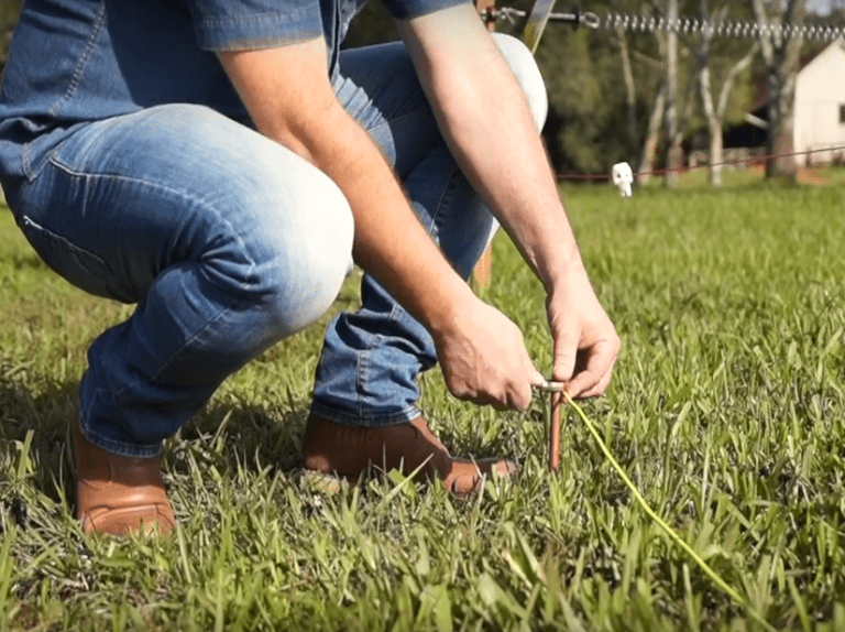 aterramento da cerca elétrica sendo demonstrado por homem